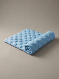 Tapis rafraîchissant Koozy bleu ciel en soie glacée, partiellement roulé